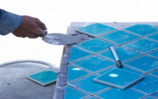 This image shows a man installing pool tile.