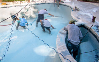 This image shows a group of men repairing pool a pool.